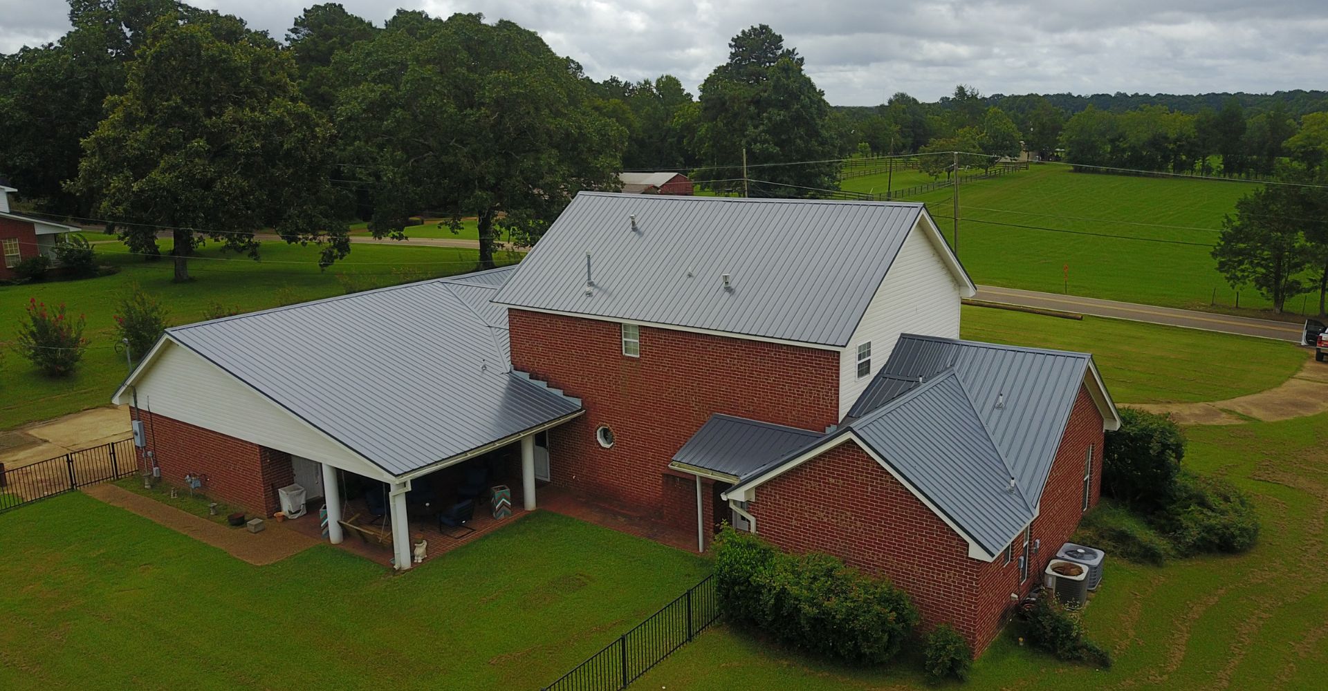 A new metal roof on a large barn in a country setting.