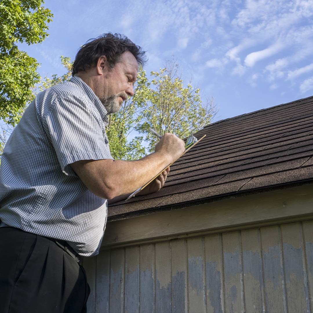 A man is inspecting a roof.