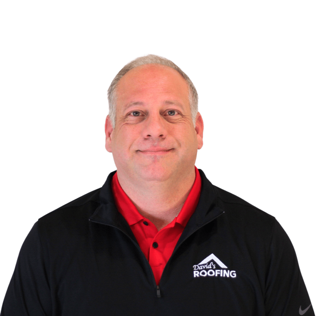 A man in a black top with "David's Roofing" logo, red shirt underneath, smiles with a plain background.