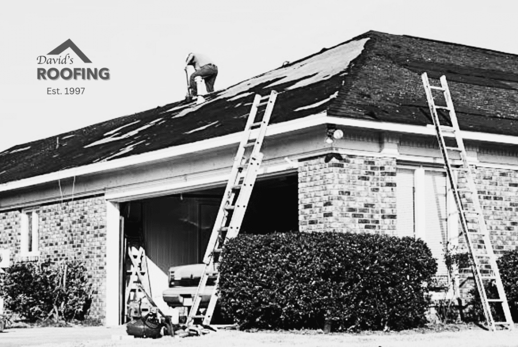 Person working on the roof of a brick house with ladders positioned against it. A logo reads "David's Roofing, Est. 1997.