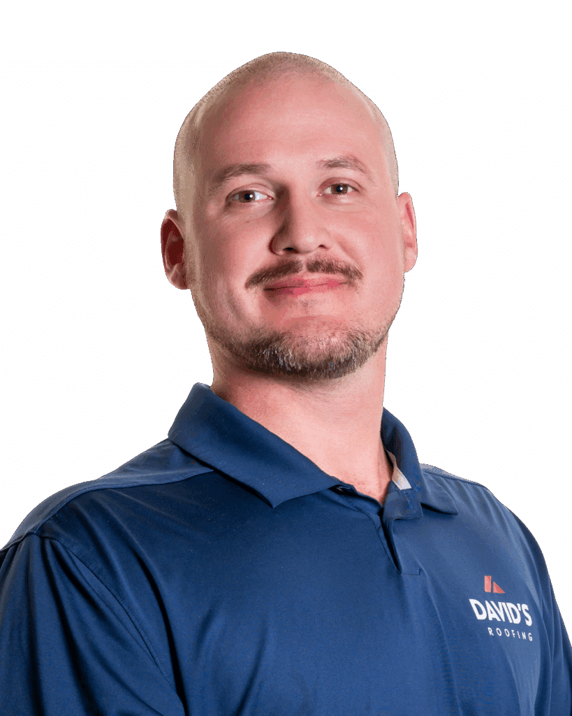A man with a shaved head and trimmed beard wearing a blue polo shirt with a "DAVID'S ROOFING" logo stands against a plain white background.